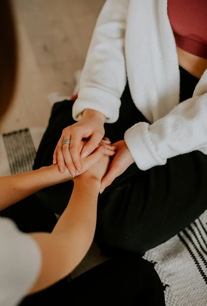 Two women holding hands, doula offering supportive presence to an expecting mother in Singapore