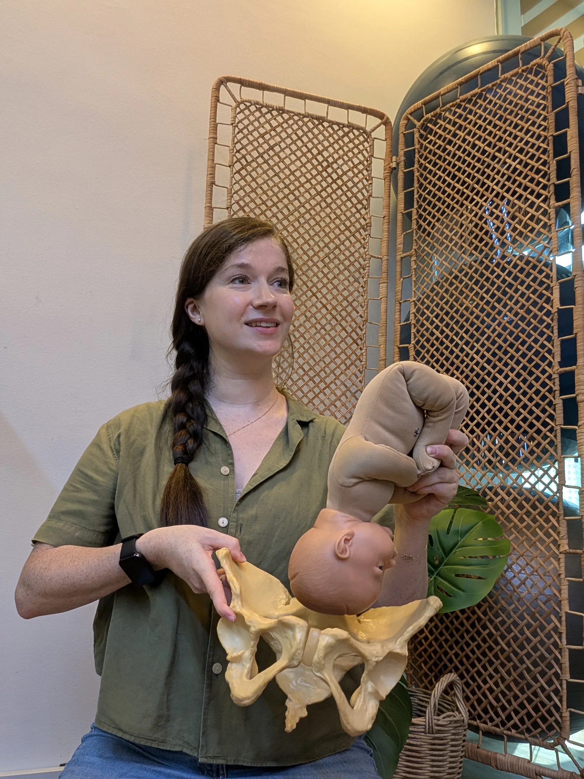 Charlotte teaching baby positioning with anatomical models during HypnoBirthing® classes in Singapore